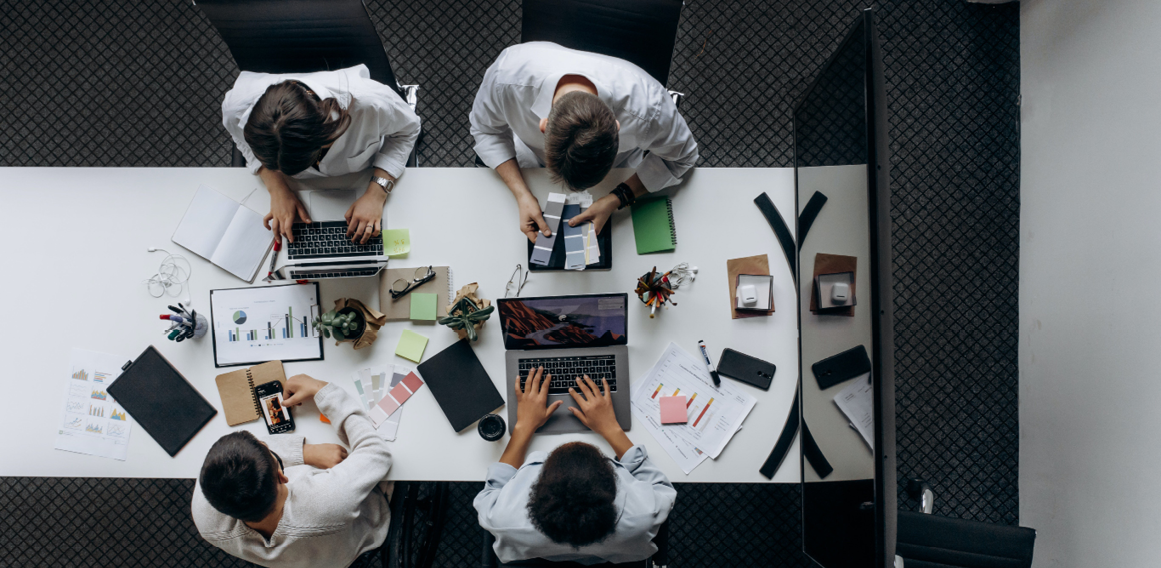 Personas en oficina reunidas en mesa de trabajo