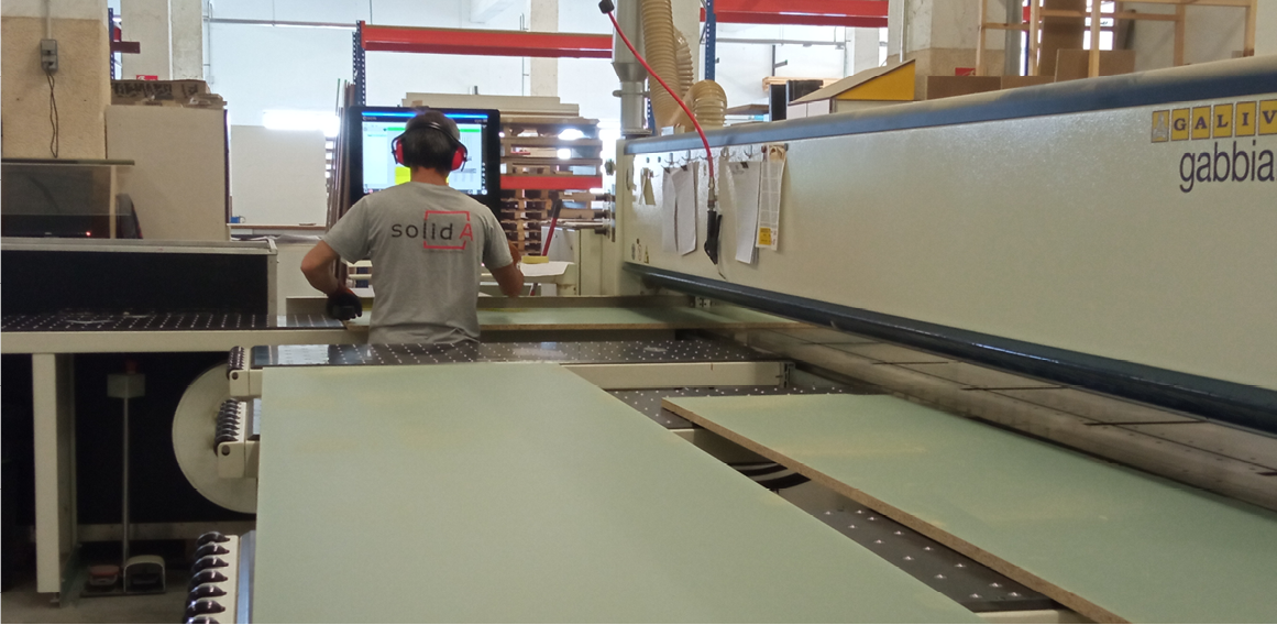 Operario de fábrica de carpintería a medida con maquinaria y tecnología