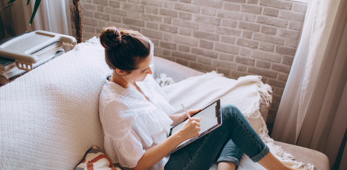 Mujer sentada en sofá con libreta pensamientos e inspiración