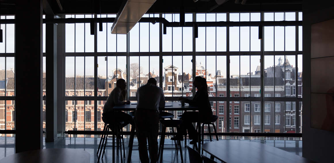 sala de reuniones en una oficina híbrida con un ventanal y mesa de trabajo