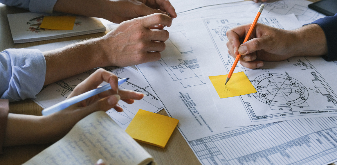 Empleados con planos de arquitectura con proyecto de oficina y reforma