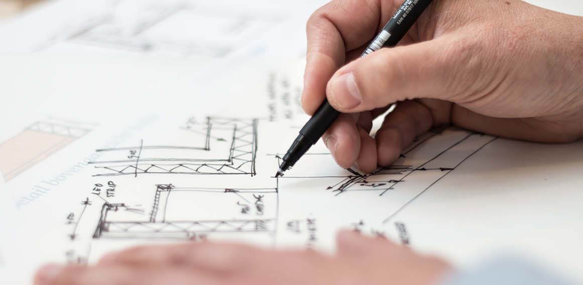 Arquitecto con bolígrafo dibujando un plano