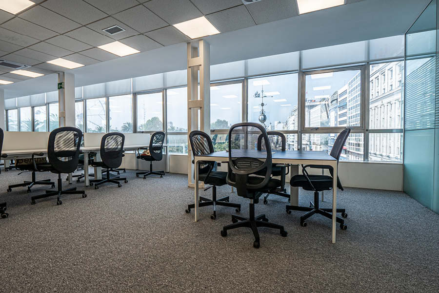 Espacio de trabajo con puestos operativos y mesas de reuniones