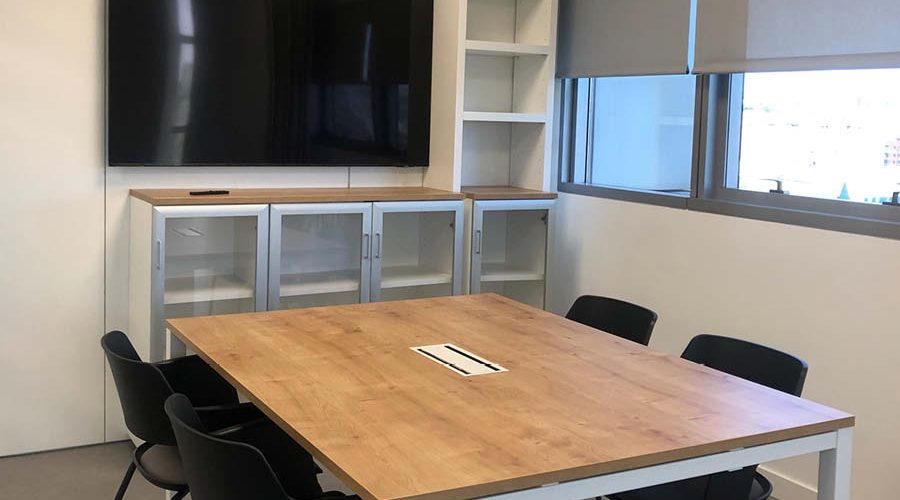 Sala de reuniones equipada con tecnología y mobiliario estándar