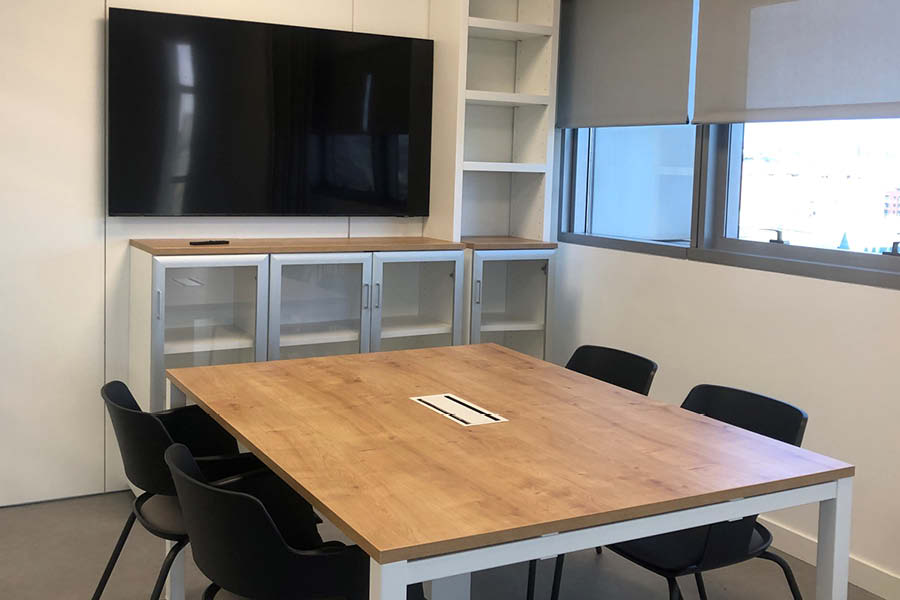 Sala de reuniones equipada con tecnología y mobiliario estándar