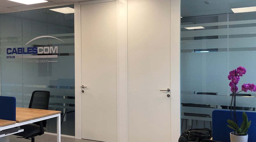 Zona de despachos compartimentada mediante mamparas de vidrio decoradas con vinilos y con equipamiento estándar completo