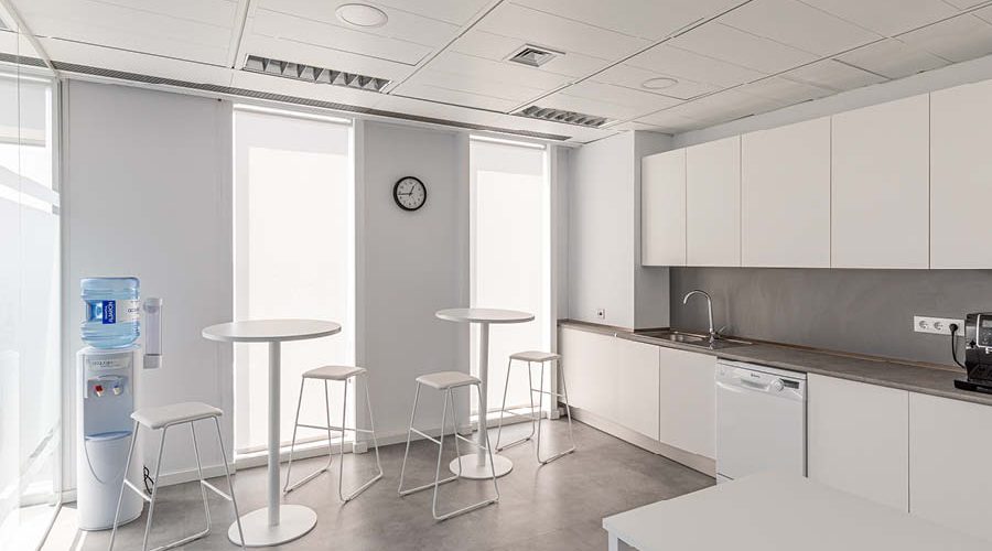 Zona de office con mobiliario de madera y carpinteria a medida, taburetes altos