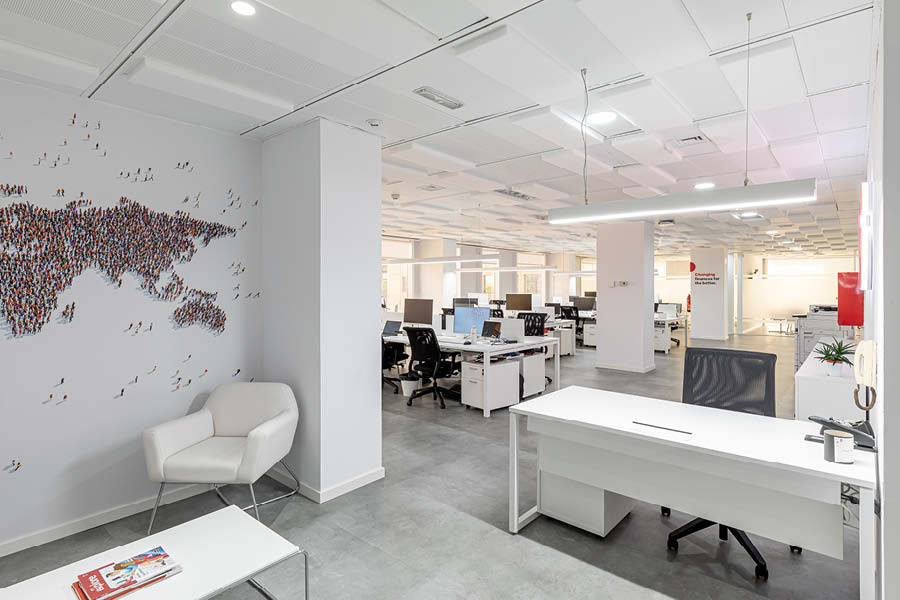 Zona de oficina con puestos operativos, mesa de recepcion, iluminacion natural y artificial, diseño de oficina