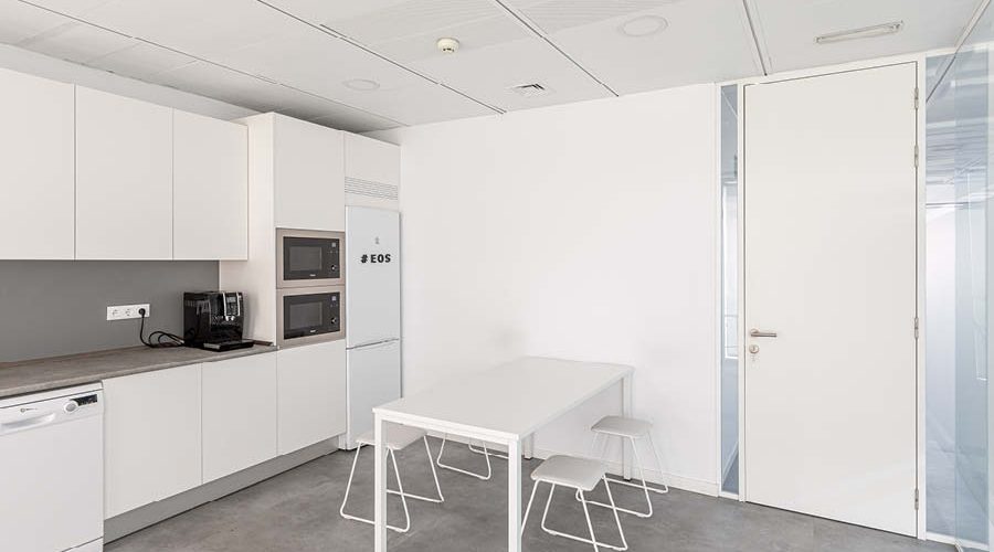 Zona de office con mobiliario a medida, electrodomesticos, cerramiento y mesa y sillas de comedor