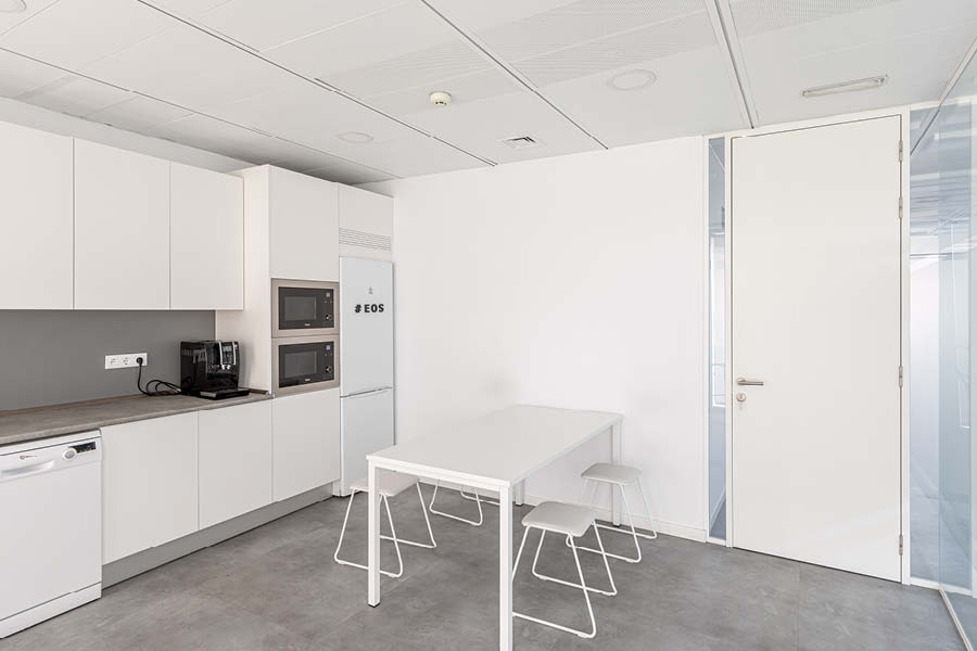 Zona de office con mobiliario a medida, electrodomesticos, cerramiento y mesa y sillas de comedor