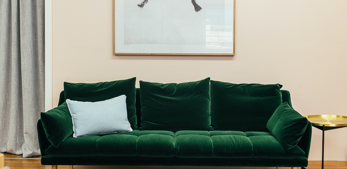 sofá de terciopelo verde siguiendo tendencias de diseño de interiores