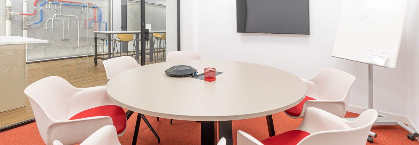 Sala de reuniones pequeña con espacio para equipo de trabajo y videollamadas