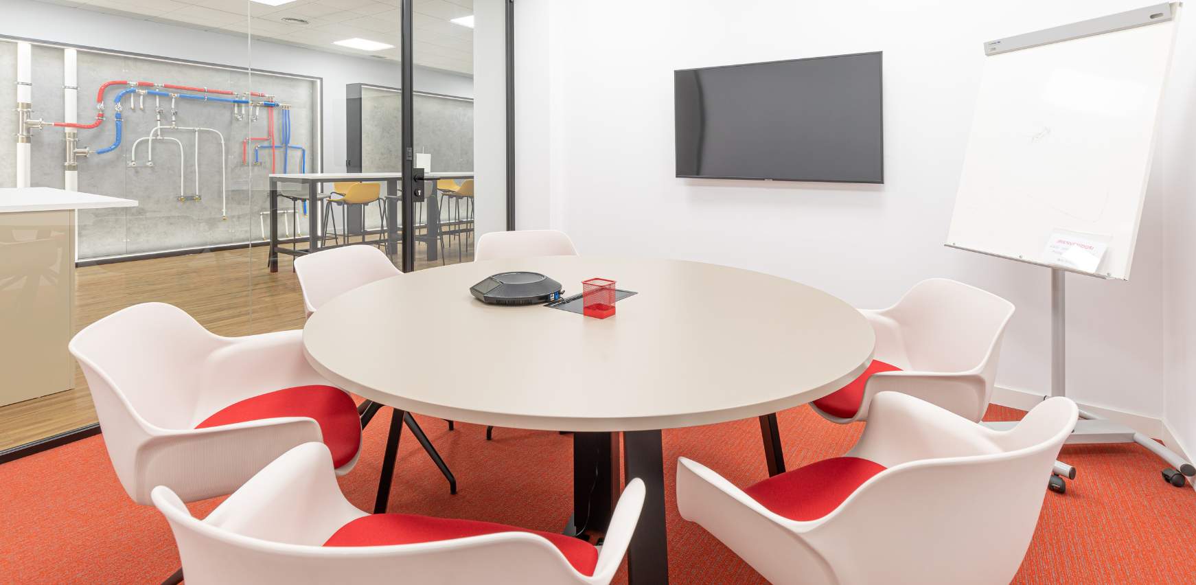 Sala de reuniones pequeña con espacio para equipo de trabajo y videollamadas