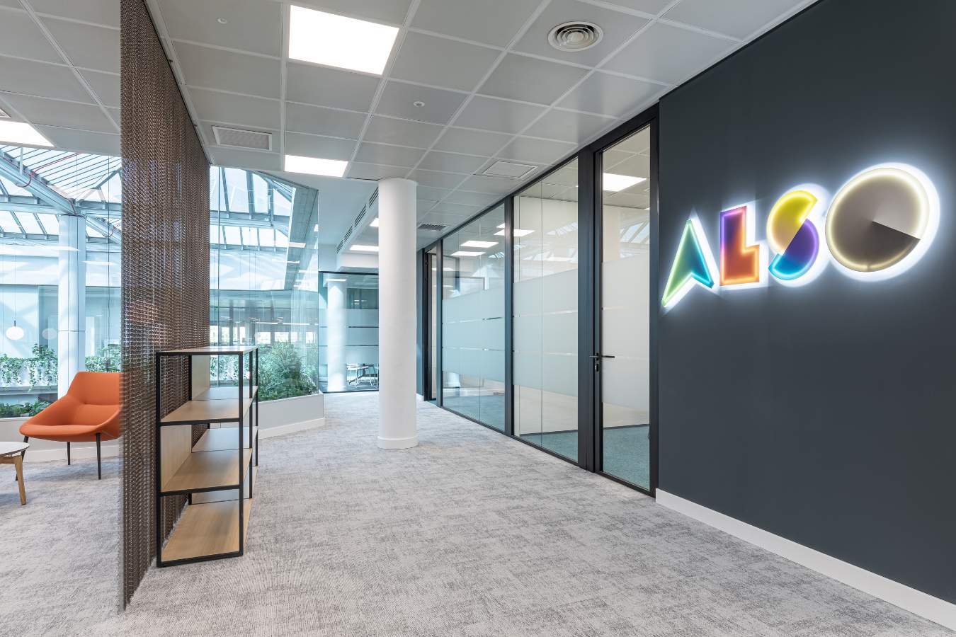Rótulo corporativo en oficina en Madrid, zona de recepción con moqueta y mamparas