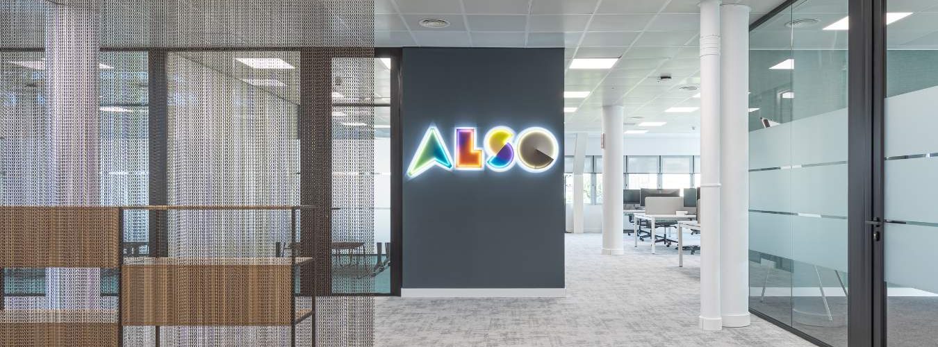 Hall de entrada en oficina en Madrid con mobiliario corporativo y rótulo luminoso