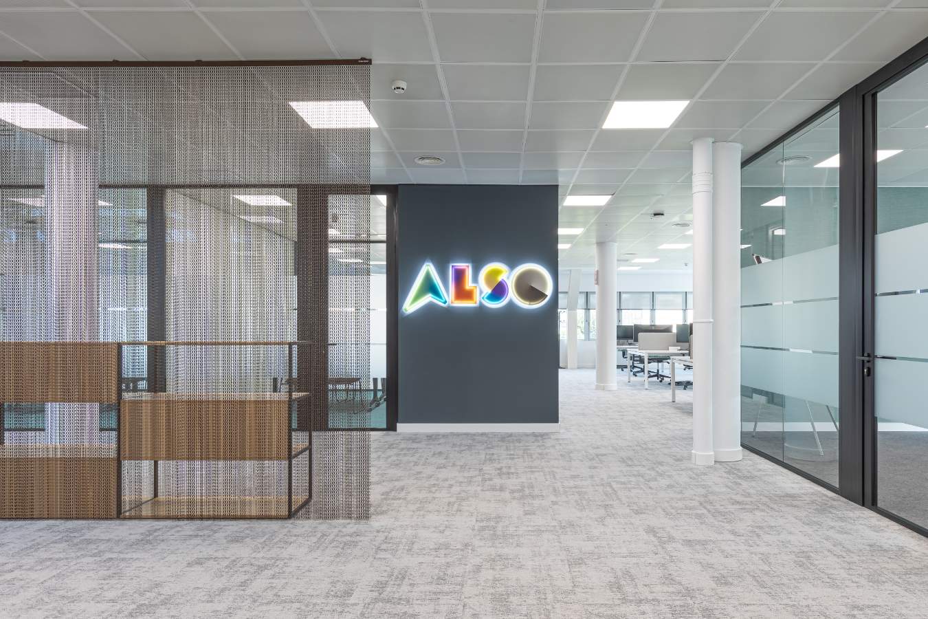 Hall de entrada en oficina en Madrid con mobiliario corporativo y rótulo luminoso