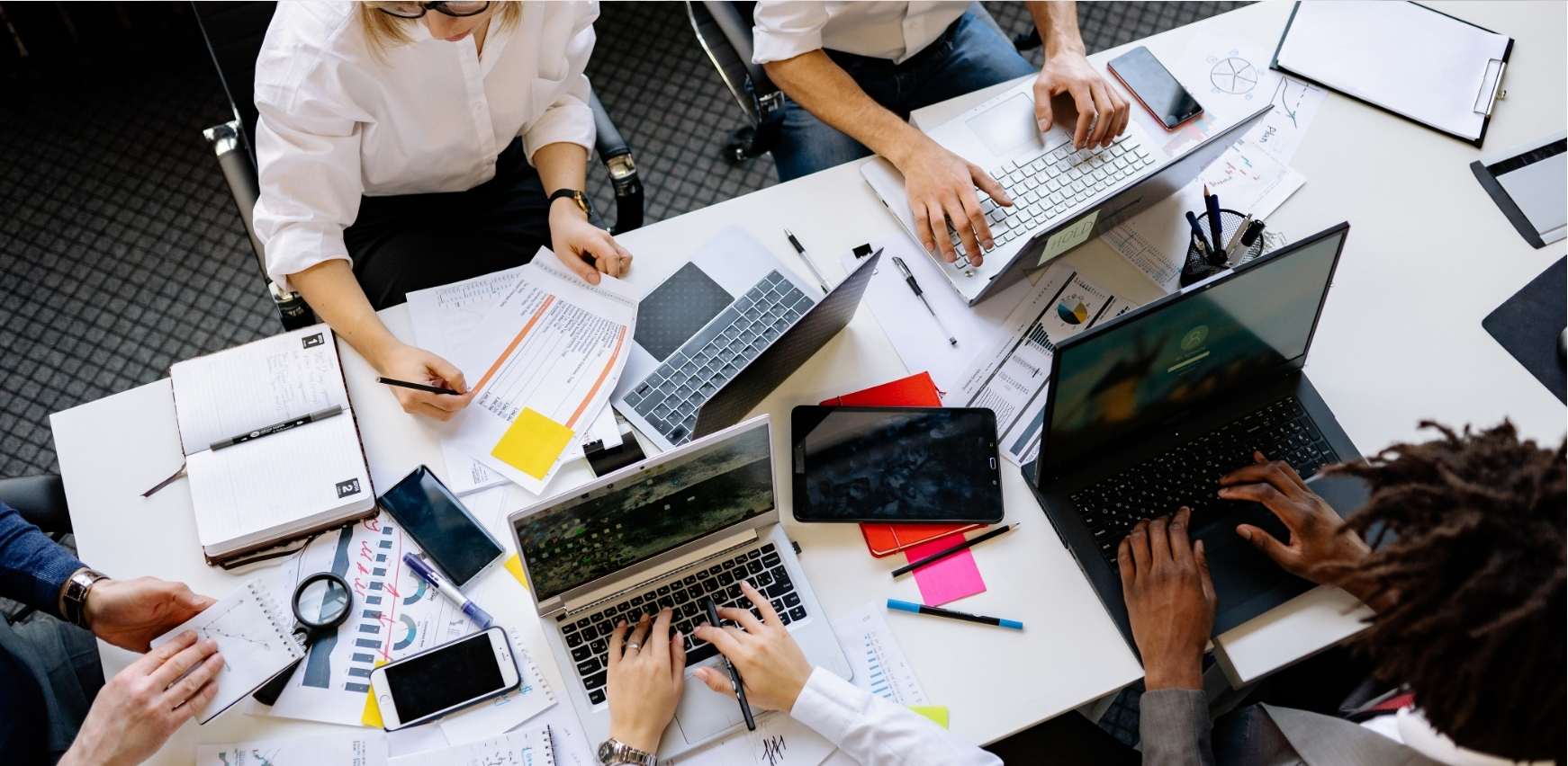 Zona de trabajo con varias personas del equipo trabajando coordinadas