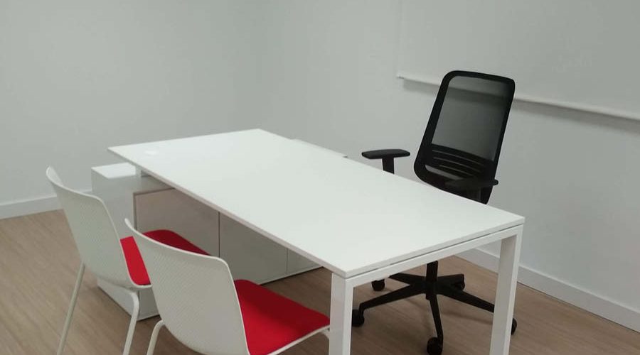 Despacho en Torneiro equipado por Solida Equipamiento Integral con mesas funcionales y sillas operativas en colores corporativos