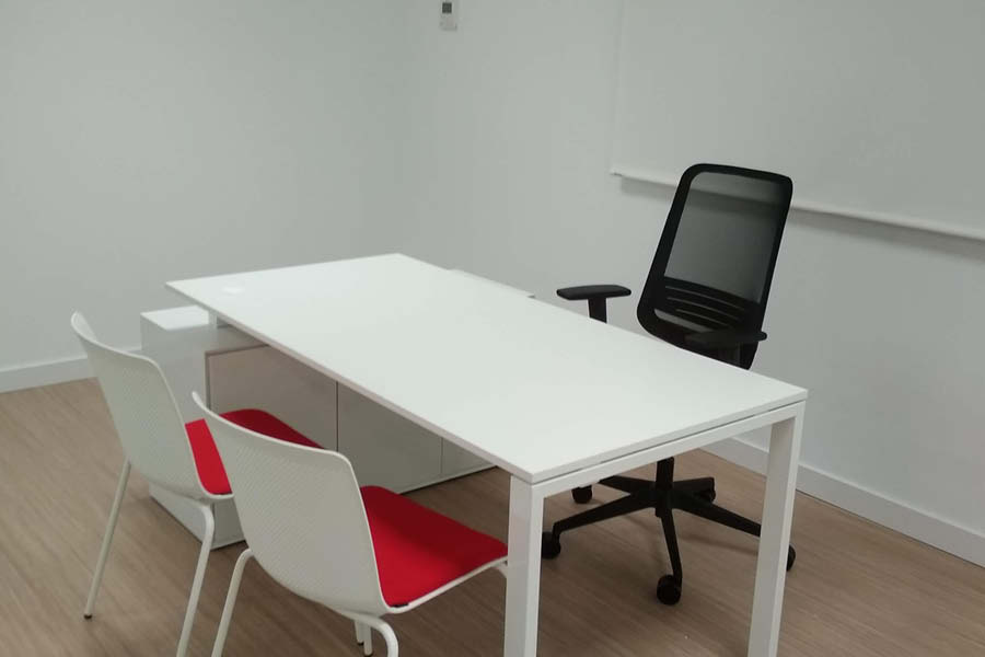 Despacho en Torneiro equipado por Solida Equipamiento Integral con mesas funcionales y sillas operativas en colores corporativos