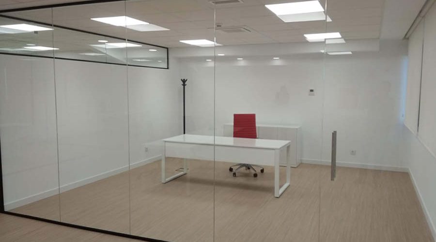 Oficinas reformadas por Solida Equipamiento Integral con compartimentación con mamparas y mobiliario estándar funcional en colores corporativos