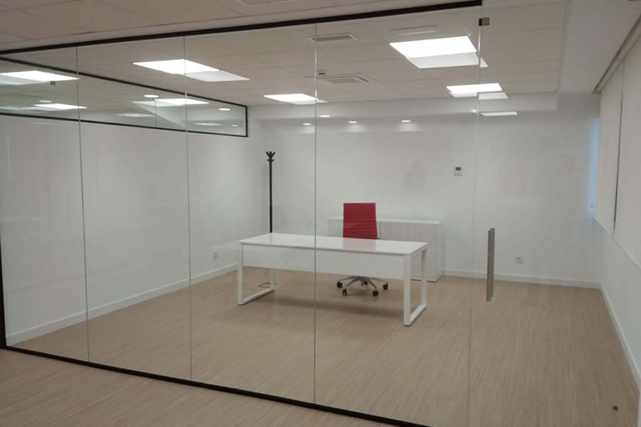 Oficinas reformadas por Solida Equipamiento Integral con compartimentación con mamparas y mobiliario estándar funcional en colores corporativos